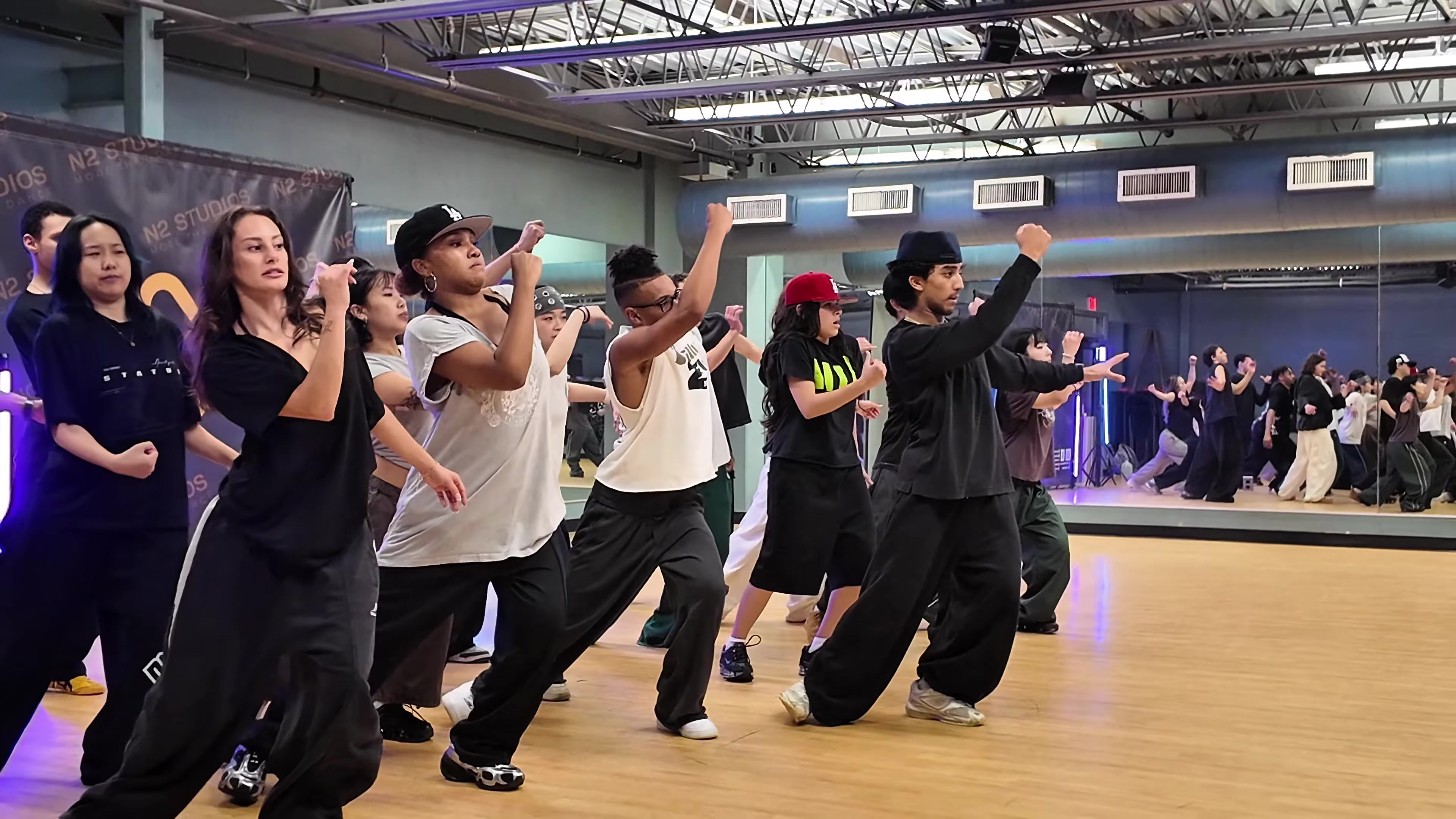 A group of dancers learning choreography together at an N2 workshop.